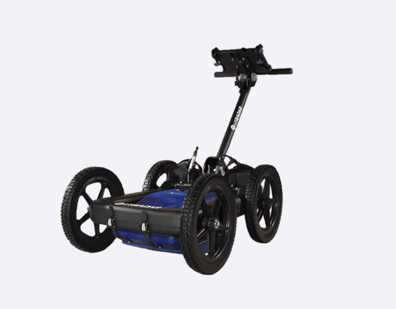 Four-wheeled all-terrain mobility cart with a vertical handlebar and blue battery pack, designed for rugged travel.